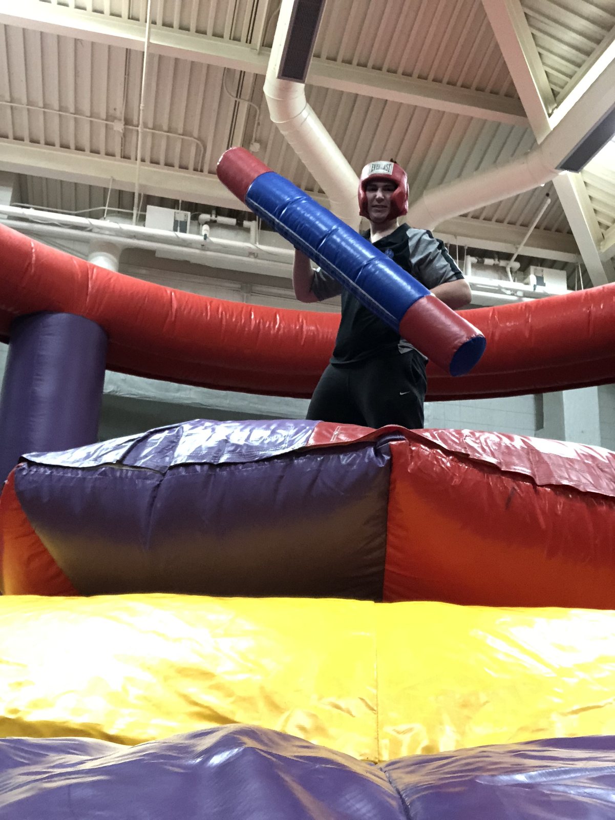 Teen guest playing an inflatable jousting game indoors